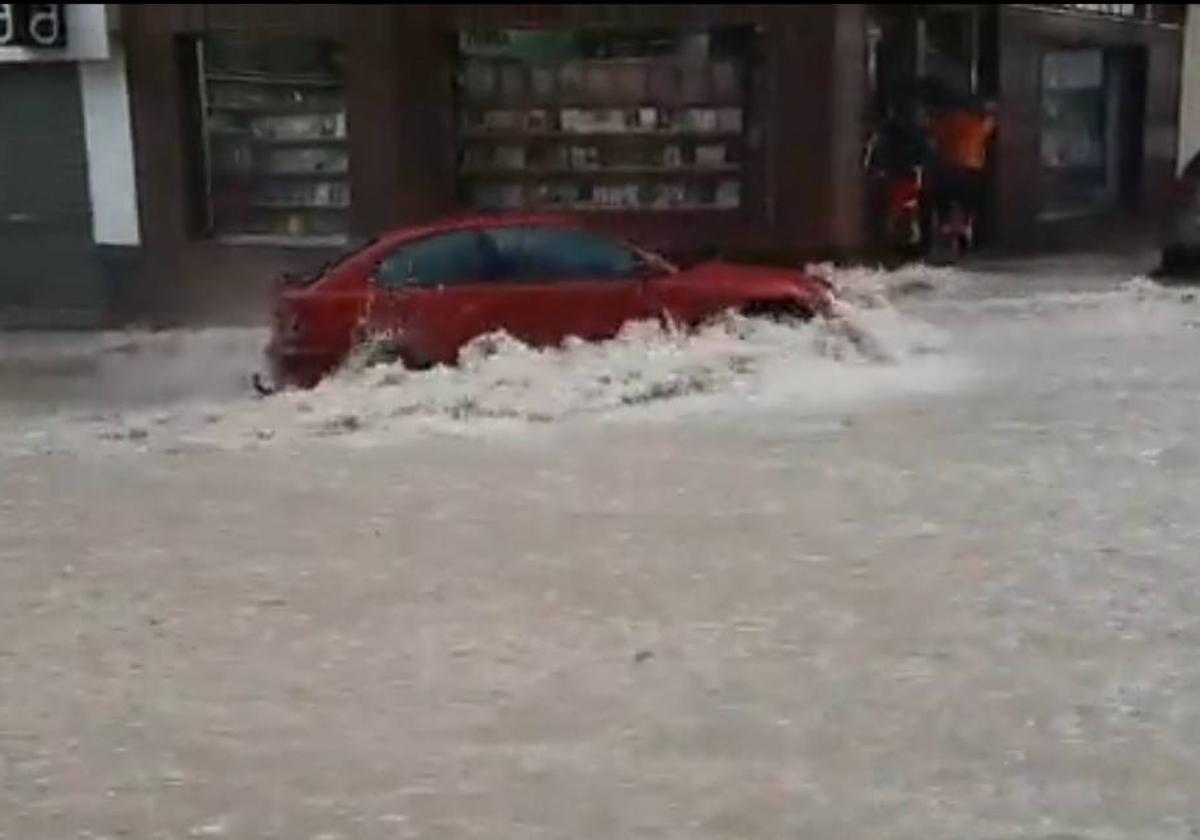 Un coche es arrastrado por la corriente.