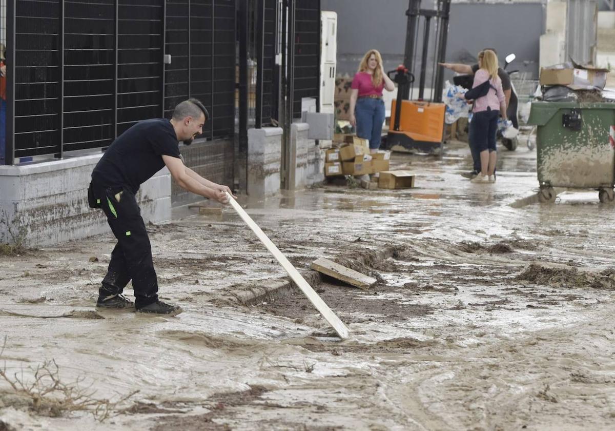 Un vecino de Molina trabaja para intentar arreglar una calle arrasada por la lluvia.