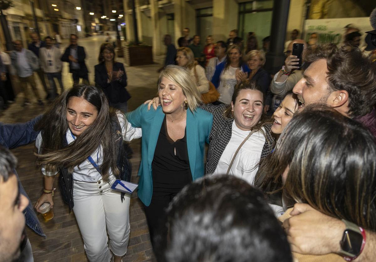 Noelia Arroyo, en el centro, baila con jóvenes del PP este domingo por la noche, a su llegada a la sede de campaña para celebrar su victoria.