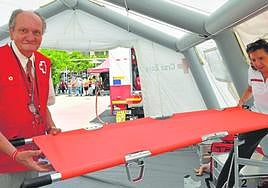 Los voluntarios Francisco y Reme transportan una camilla en una de la tiendas de Cruz Roja en Murcia.