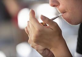 Una mujer se enciende un cigarro en una imagen de archivo.