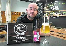 Andrés Carrasco junto a su premiada cerveza Marítima, en el bar de la Plaza San Francisco.
