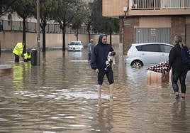 Dos personas cruzan una calle inundada en Cartagena en un día lluvioso del pasado mes de mayo.
