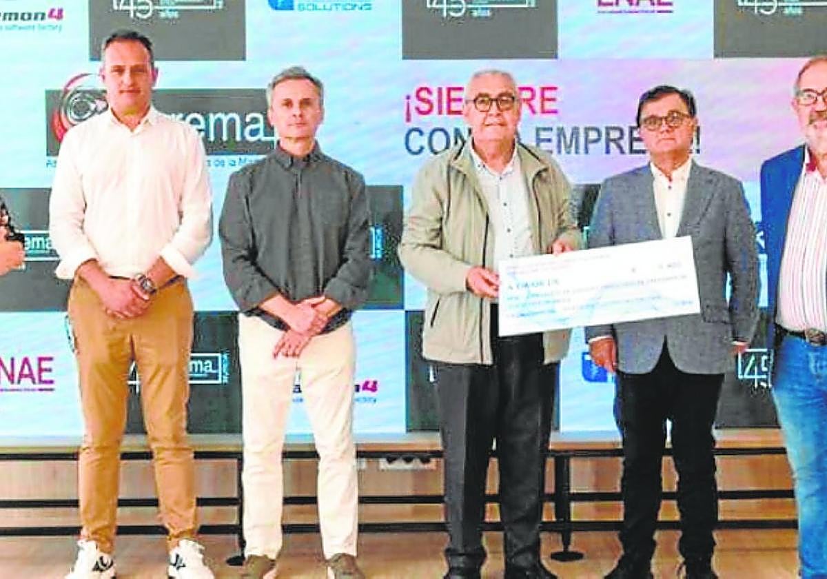 Representantes de ambas asociaciones, en la entrega del cheque.