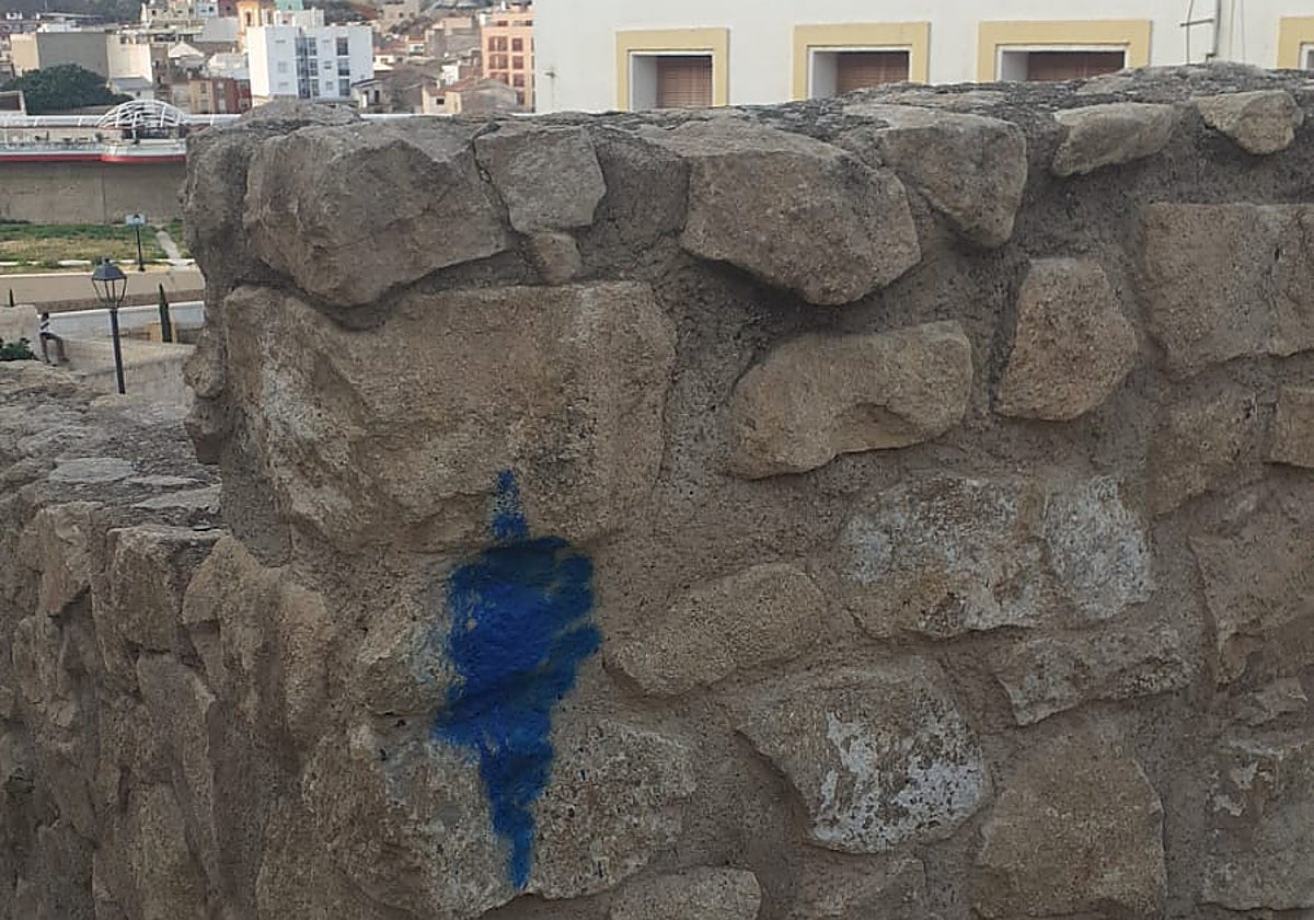 Pintada realizada con aerosol de color azul en la muralla medieval.