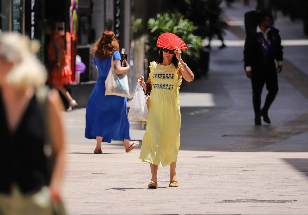 Una mujer trata de protegerse del sol con un abanico, el pasado viernes, en Murcia.