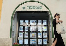 Una mujer pasa junto a una inmobiliaria, en una foto de archivo.