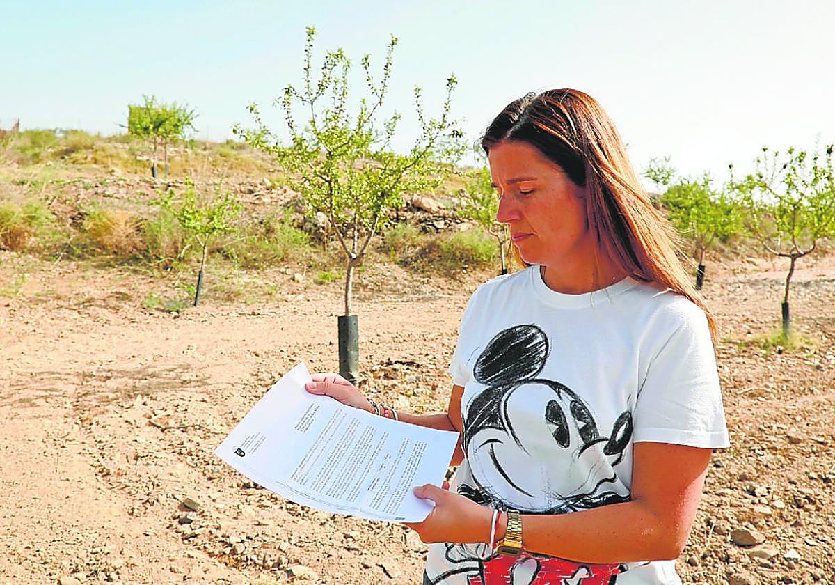 María del Carmen Martínez, en su finca, con la carta que ha recibido de la Comunidad.