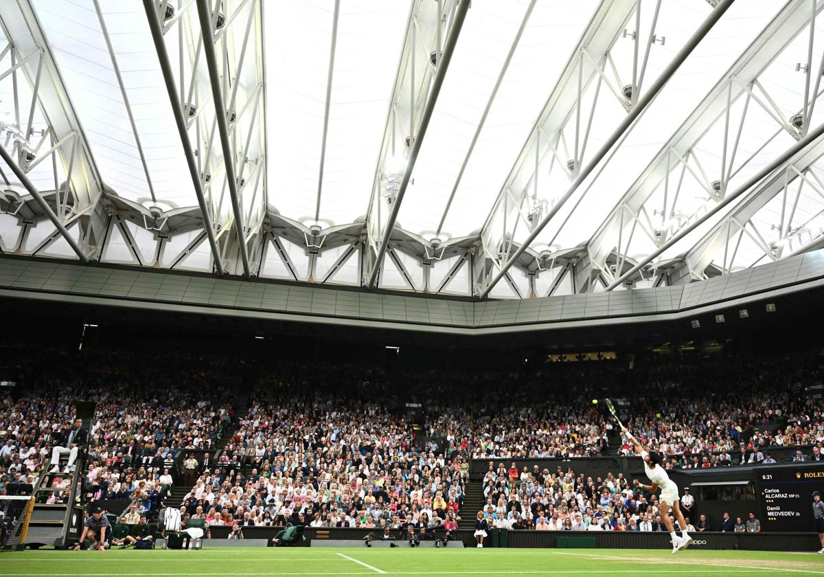 Carlos Alcaraz realiza un saque en la central de Wimbledon, este viernes ante Medvedev.