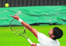 Alcaraz lanza la bola al aire para sacar en un juego de la final de Wimbledon contra Djokovic, el domingo.