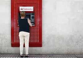 Una mujer sacando dinero del cajero, en una imagen de archivo.