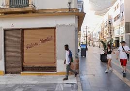 Comercidos cerrados en la calle Corredera de Lorca.