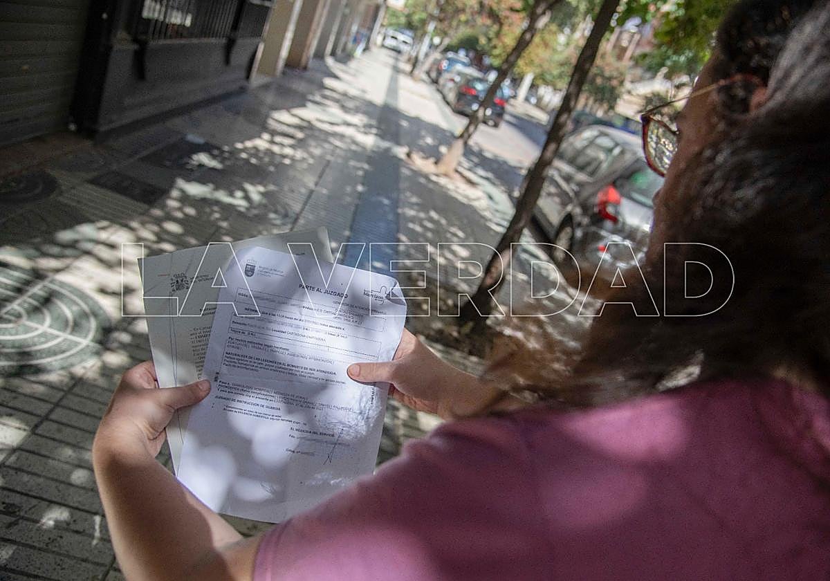 Lili muestra la denuncia que ha interpuesto ante la Policía, junto al parte de lesiones.