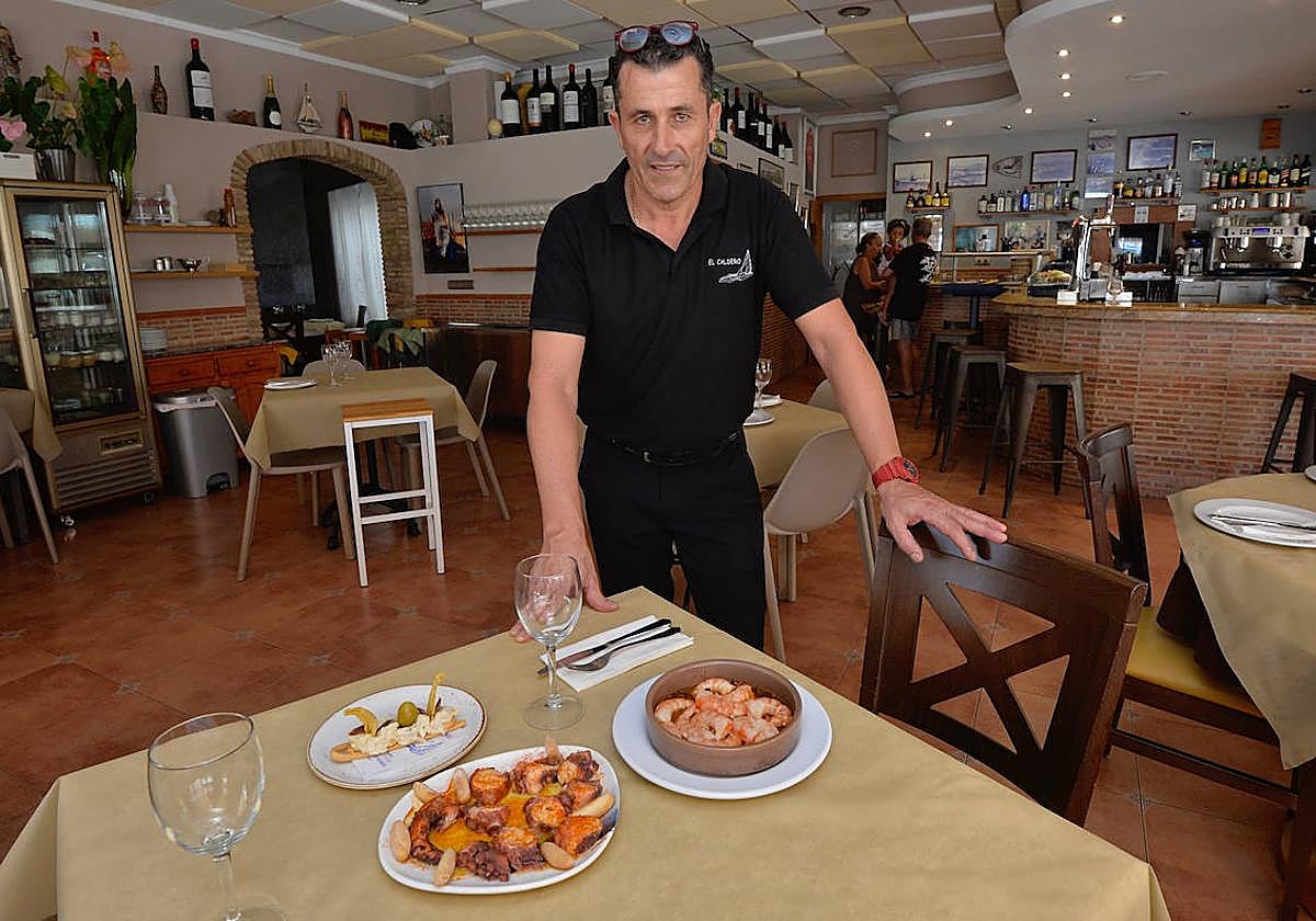 Alberto 'El Rapao' con los platos de pulpo y gambas al ajillo en su restaurante El Caldero, en el Club de Regatas del puerto de Mazarrón.