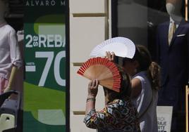 Dos mujeres se protegen del sol con un abanico, en una imagen de archivo.