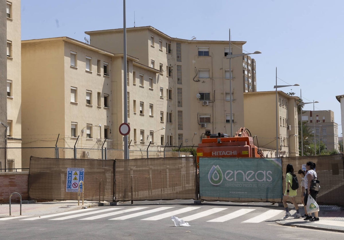 Tres personas pasan frente a las máquinas que derribarán el cuartel de la Guardia Civil.