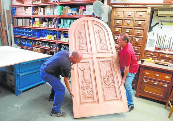 El restaurador Antonio García Rico (derecha) y un operario del taller municipal, con la puerta.
