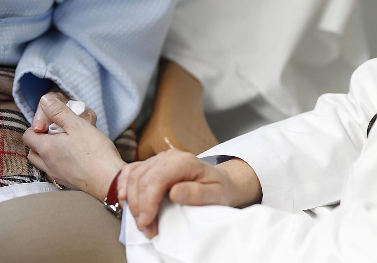 Un sanitario, miembro de un equipo de cuidados paliativos, consuela a un paciente.