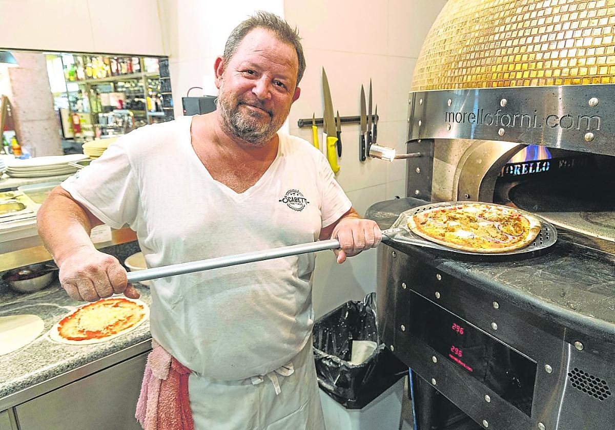 Ian Reyner saca una pizza del horno de la pizzería Scabetti de Los Belones.
