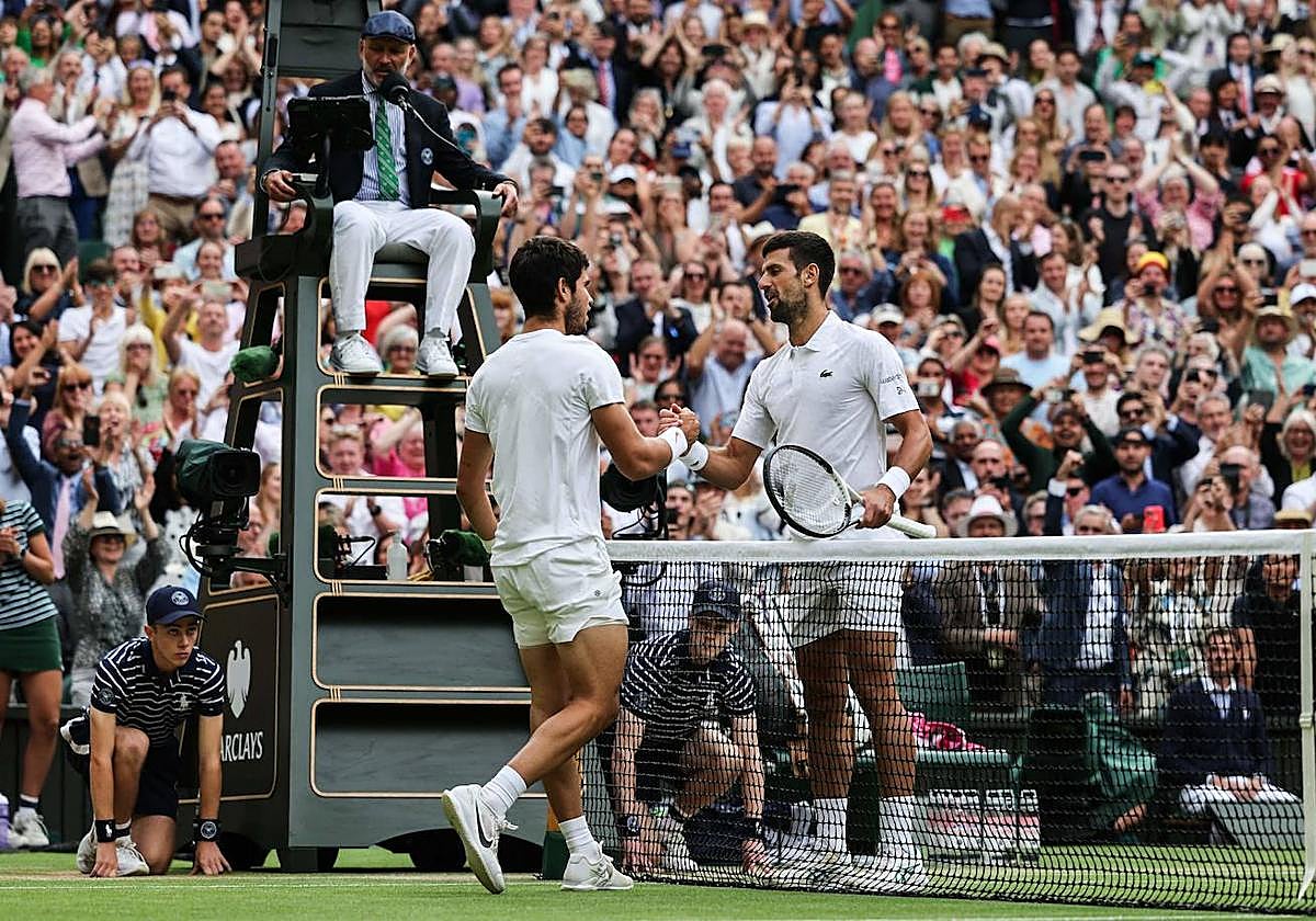 Carlos Alcaraz y Djokovic se dan la mano tras la final que ganó el murciano al serbio en Wimbledon, el 16 de julio.