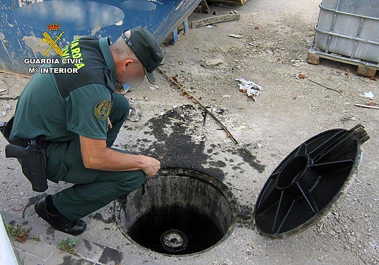 Un agente inspecciona el depósito de aceite de automoción.