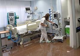 Una sanitaria de la UCI de La Arrixaca prepara una cama en una imagen de archivo.