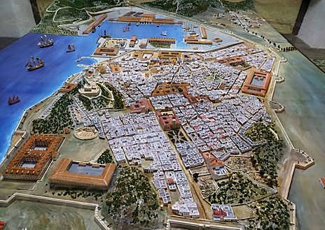 Imagen secundaria 1 - Escuela romana impartiendo clase desde la cátedra; maqueta de Cartagena en el siglo XVIII y cátedra de Maximiano. 