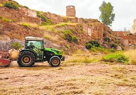 Un tractor corta maleza en los solares de la calle Morería.