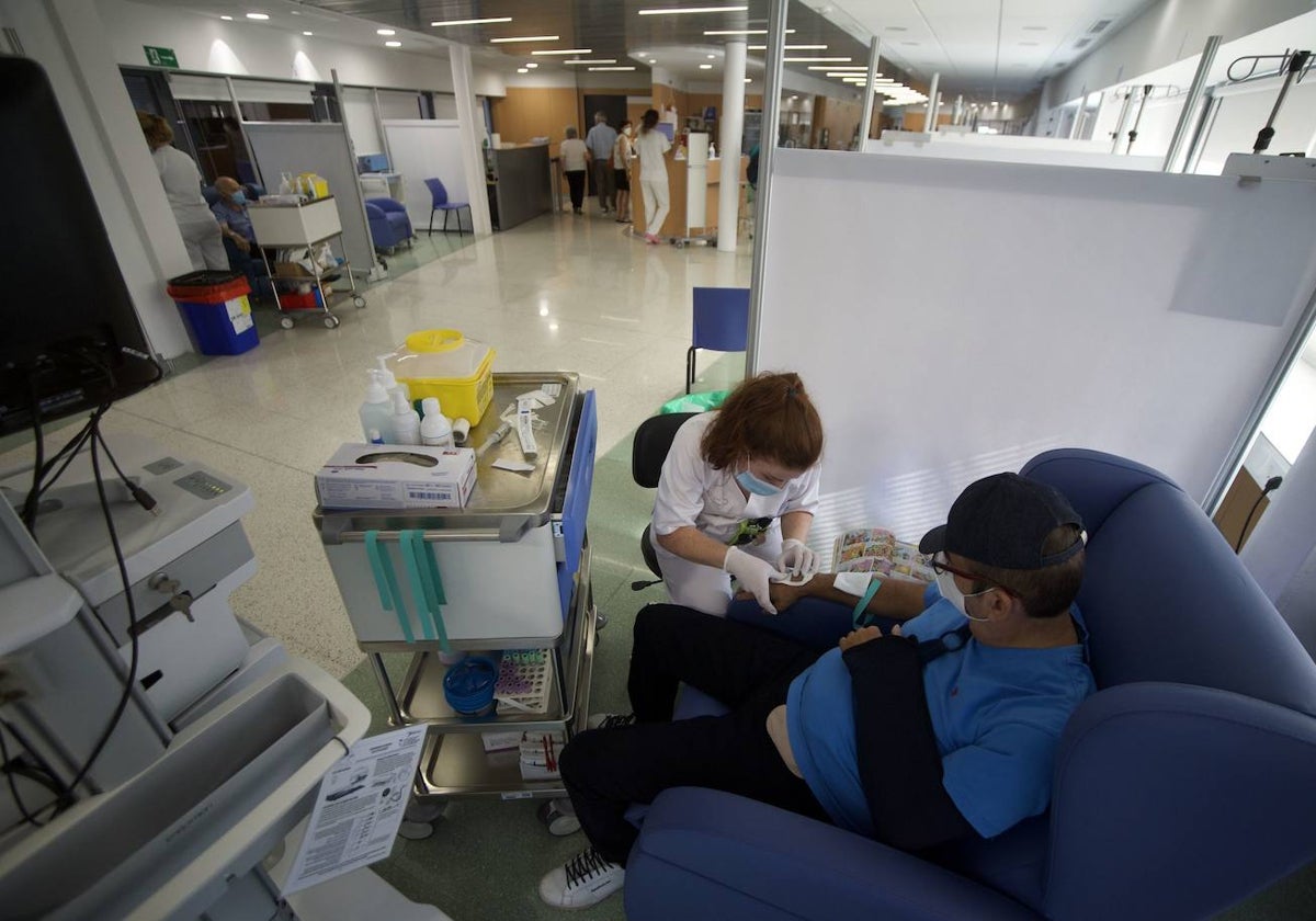 Una enfermera administra un tratamiento a un paciente en el hospital de día del pabellón oncohematológico del Morales Meseguer