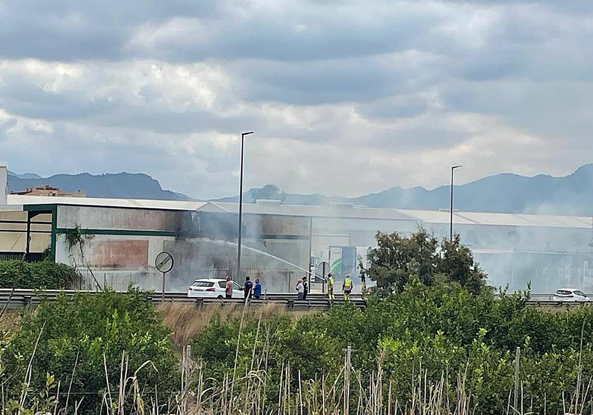 Bomberos tratan de sofocar las llamas.