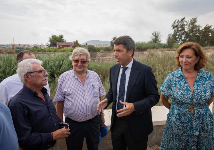 El president Carlos Mazón visita junto a la alcaldesa de Almoradí, María Gómez, el lugar en el que la mota del río Segura colapsó durante la Dana de 2019.