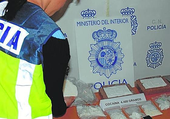 Un agente de la Policía Nacional custodia uno de los alijos de cocaína intervenidos en la etapa que se indaga.