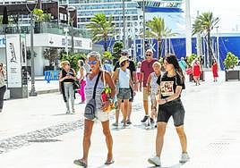 Turistas paseando por la Plaza Héroes de Cavite, ayer, y al fondo, el crucero 'Celebrity Apex', en el muelle Juan Sebastián Elcano.