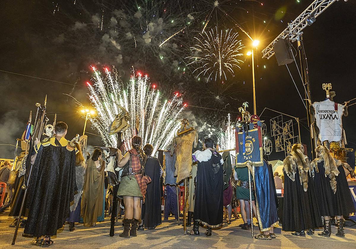 Representantes de tropas y legiones, con sus estandartes, contemplan el espectáculo pirotécnico en el fin de fiestas.