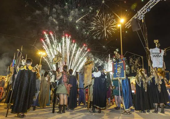 Representantes de tropas y legiones, con sus estandartes, contemplan el espectáculo pirotécnico en el fin de fiestas.