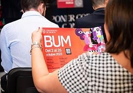 Una asistente a la presentación de la BUM lee el programa de actividades