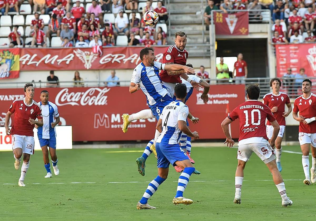 Los jugadores del Real Murcia y del Alcoyano luchan por la posesión de un balón.