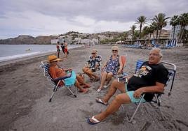 Cuatro personas mayores disfrutan de la playa.