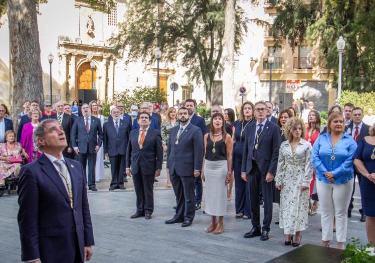 La corporación municipal e invitados asisten al izado de las banderas.