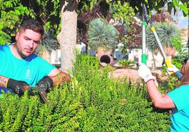 Óscar y Karla recortan un seto en el jardín Adolfo Suárez.