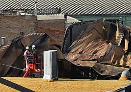 Los técnicos trabajando con grúas en la zona del incendio.