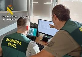 Dos agentes de la Guardia Civil trabajan macrooperación contra el cibercrimen.