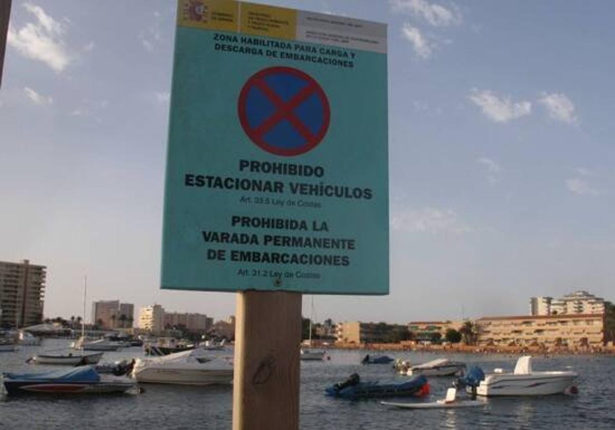 Barcos fondeados en la playa de Puerto Bello, en La Manga, frente a un cartel de prohibición. La foto es de archivo.