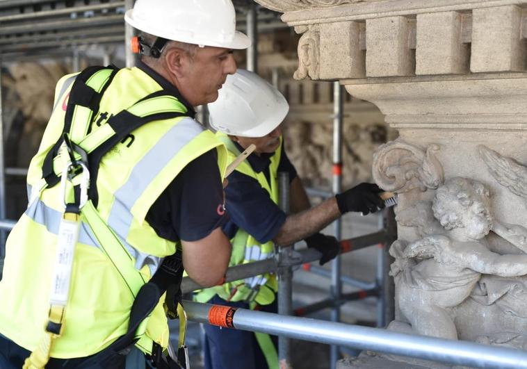 Dos obreros trabajan en la fachada de la Catedral de Murcia, este miércoles por la mañana.