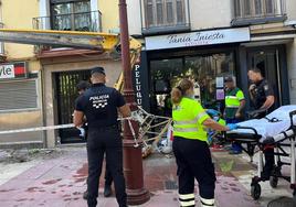 Agentes y sanitarios atienden al trabajador herido este sábado en la plaza Camachos.