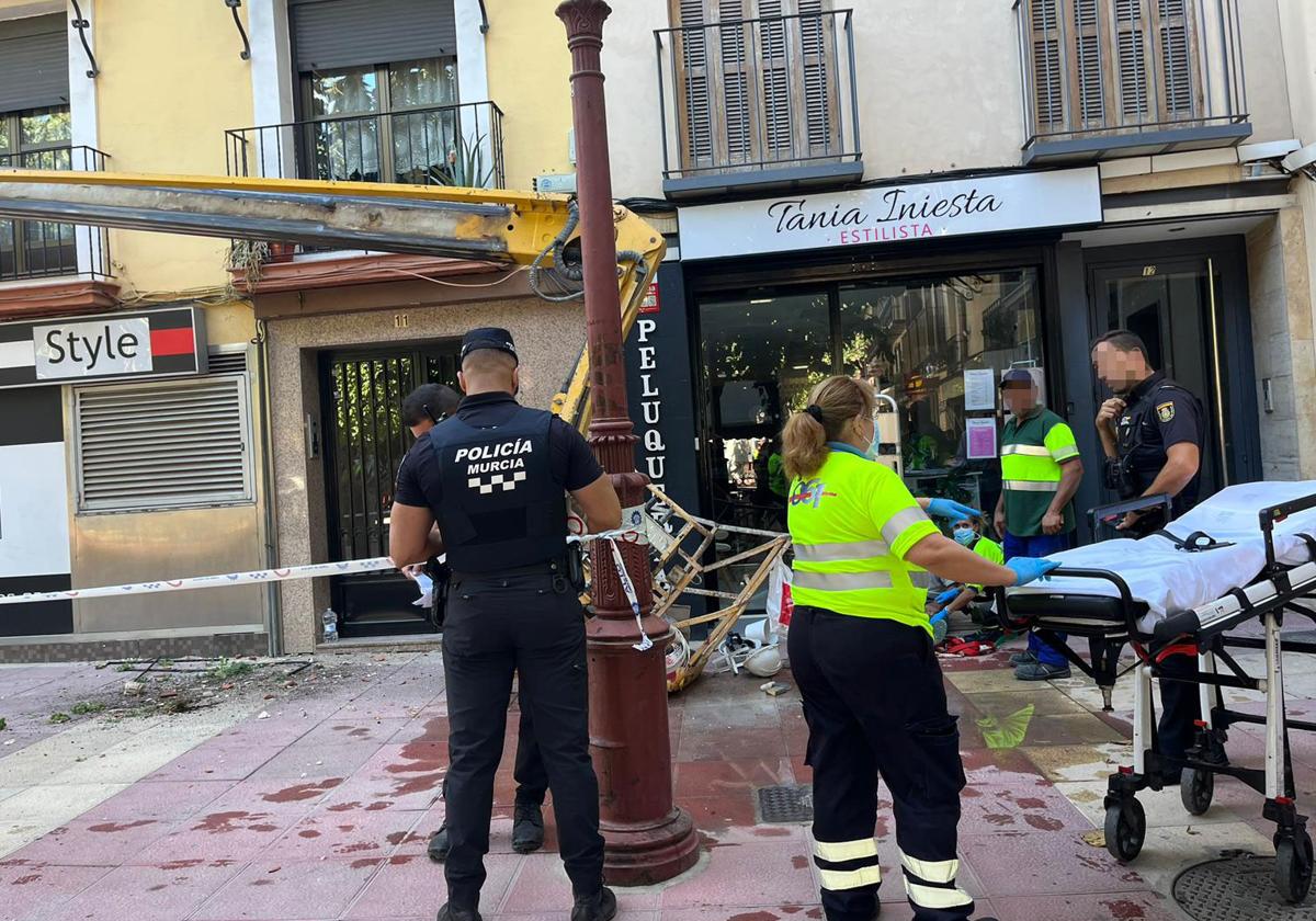 Agentes y sanitarios atienden al trabajador herido este sábado en la plaza Camachos.