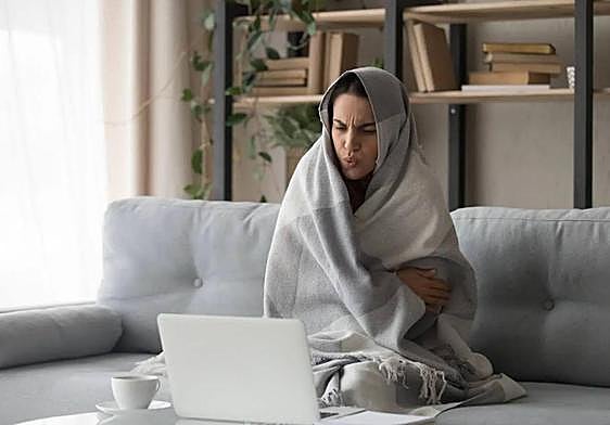 Una joven intenta combatir el frío con una manta.