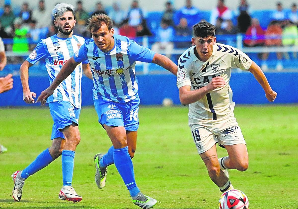 Tropi agarra de la camiseta al universitario Luque para impedir su avance, ayer, en El Rubial.