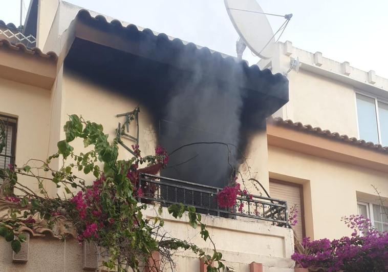 Estado en el que ha quedado la ventana de la vivienda tras el incendio.