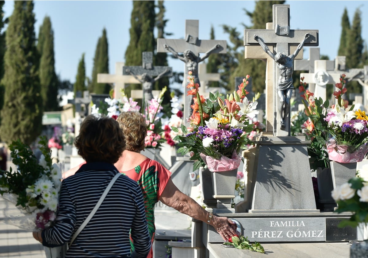Una mujer acaricia la lápida en la tumba de un familiar en el cementerio Nuestro Padre Jesús de Murcia.